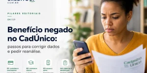 Mulher lendo documento e smartphone sobre benefício negado CadÚnico