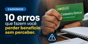 Pessoa segura cartão Cadastro Único verde enquanto escreve