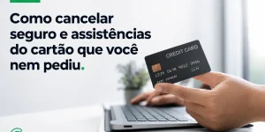 Mão segurando cartão de crédito sobre notebook para cancelar seguro não solicitado