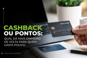 Pessoa segurando cartão de crédito em frente a laptop com planta ao fundo
