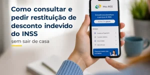 Mão segurando smartphone com app Meu INSS para consulta de restituição