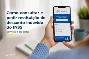 Mão segurando smartphone com app Meu INSS para consulta de restituição